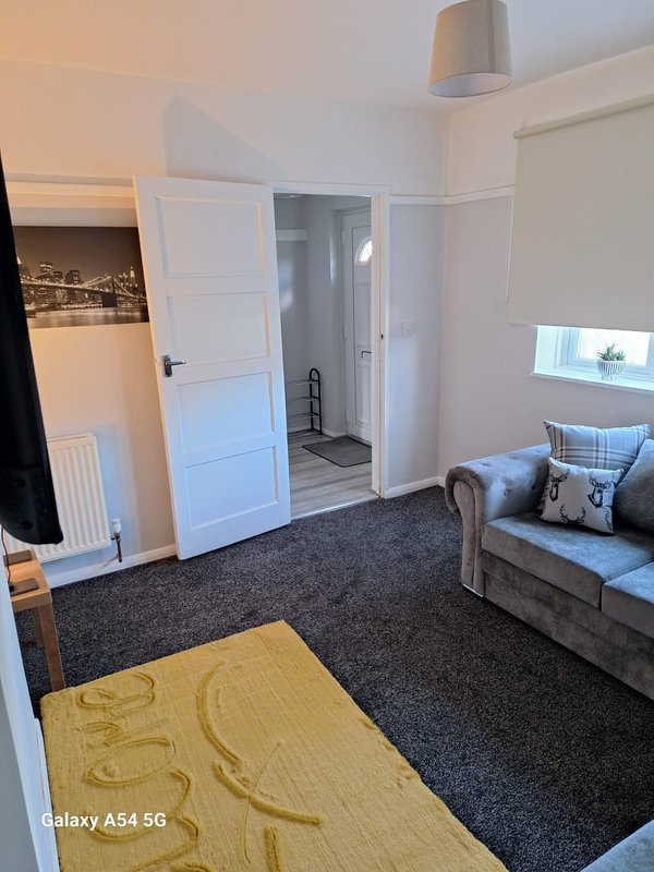 Bedroom with double bed, wooden floor mat, dark carpet, white doors and ensuite bathroom