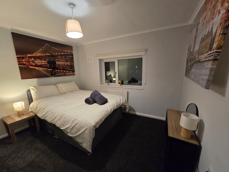Bedroom with double bed, bedside table, pendant light, and framed wall art