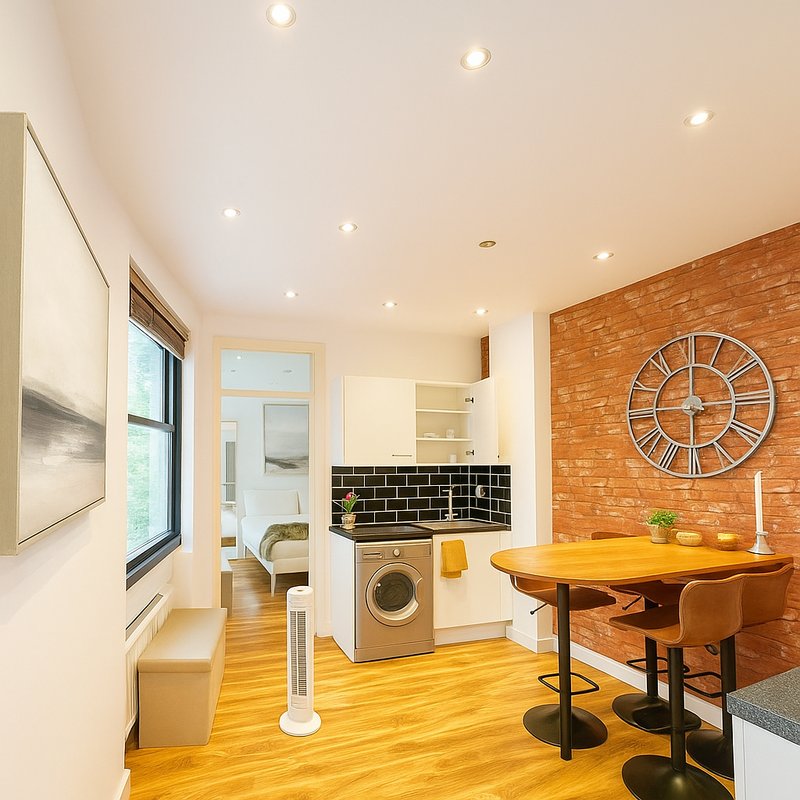 Modern kitchen and dining area with brick wall, wooden floor, and stainless steel appliances