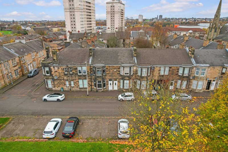Aerial view of brick terraced houses with street parking and autumn foliage