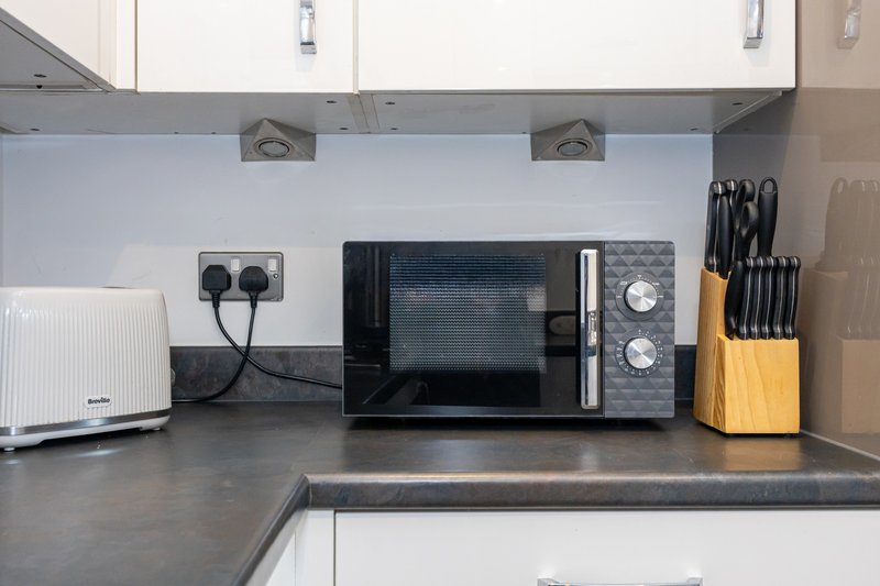 Kitchen countertop with microwave, knife block, and small appliances