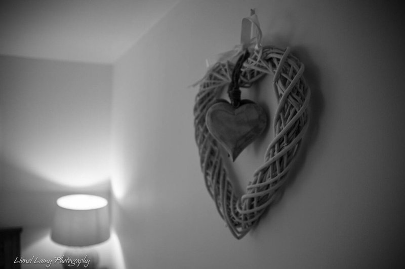 Black and white interior with decorative woven heart wall hanging and ceiling light