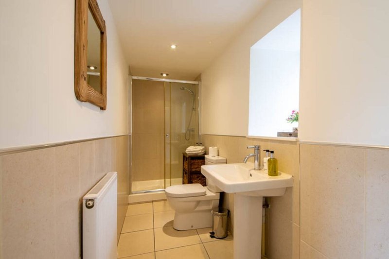 Bathroom with pedestal sink, toilet, shower enclosure and heated towel rail