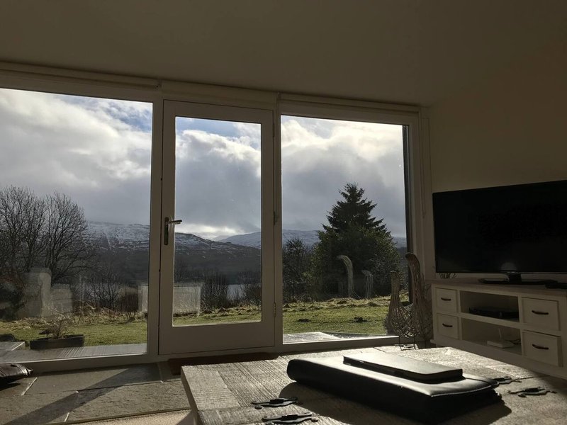 Living room with large patio doors overlooking mountain landscape and countryside views