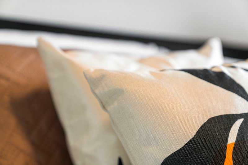 Close-up of patterned cushions and bedding with neutral and black tones