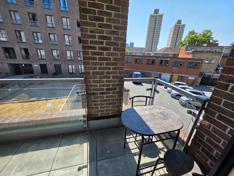Rooftop terrace with table, chairs and urban cityscape views