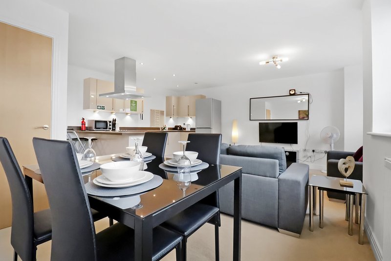 Open-plan living space with dining table, kitchen, and lounge seating area