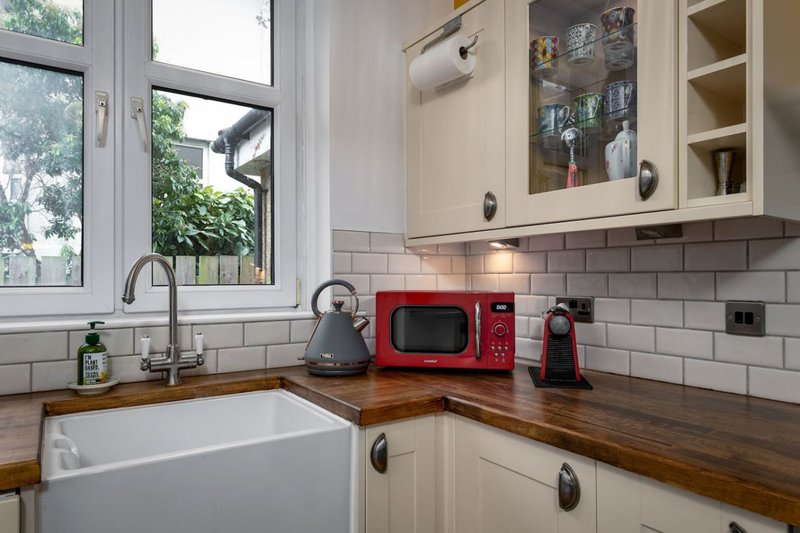 Modern kitchen with white subway tiles, wooden countertop, red microwave and appliances