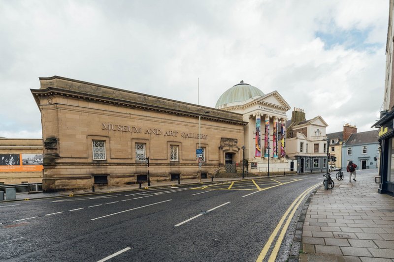 Street view of historic stone building with dome and classical architecture