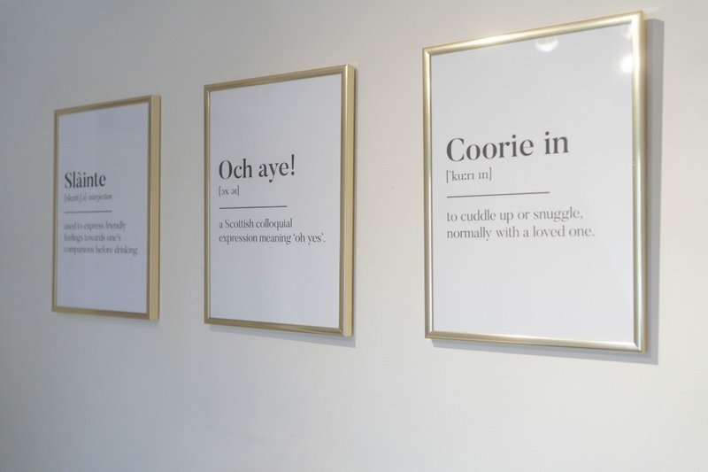 Three framed wall prints with text definitions in a modern interior space