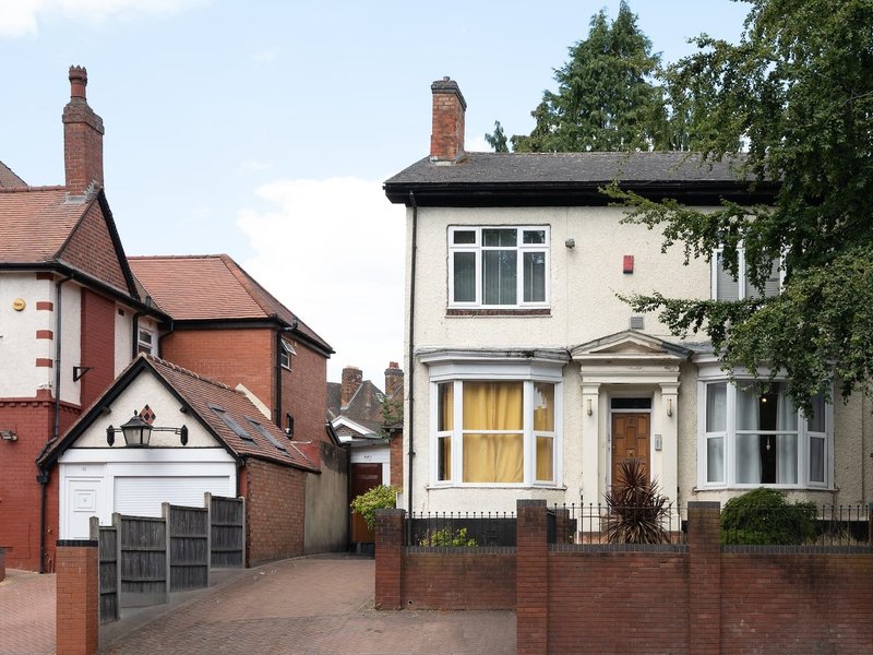 Exterior view of two brick residential properties with driveways and front gardens
