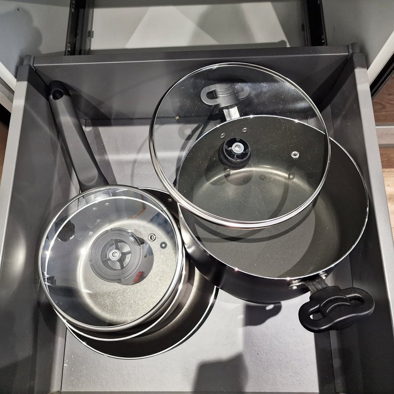Kitchen drawer with stainless steel pots and pans with glass lids