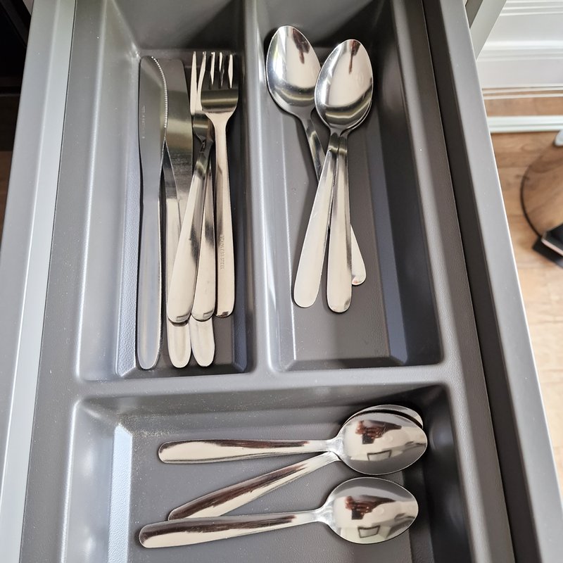 Kitchen drawer organizer with cutlery sets including forks, spoons, and knives neatly arranged