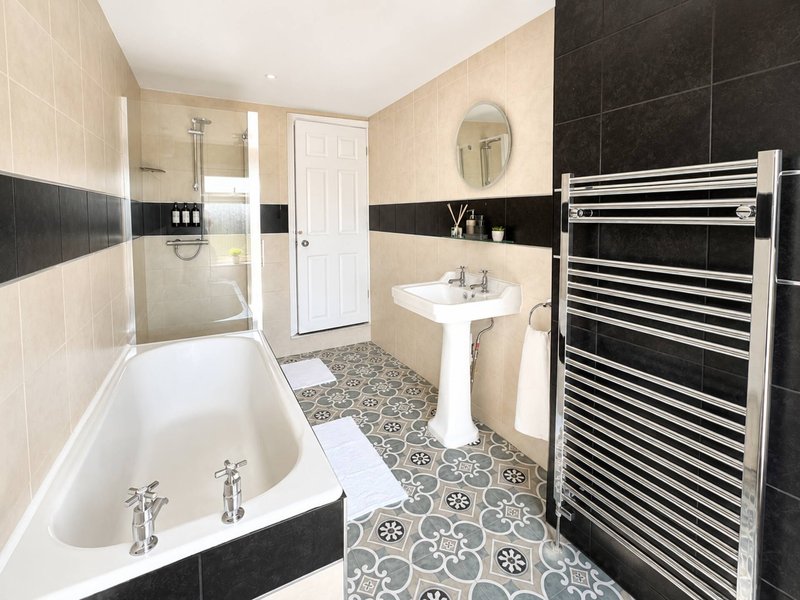 Modern bathroom with bathtub, pedestal sink, shower enclosure and heated towel rail