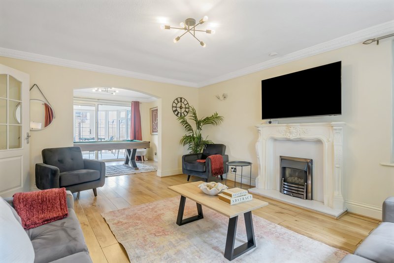 Modern living room with fireplace, flat-screen TV, wooden flooring and contemporary furniture