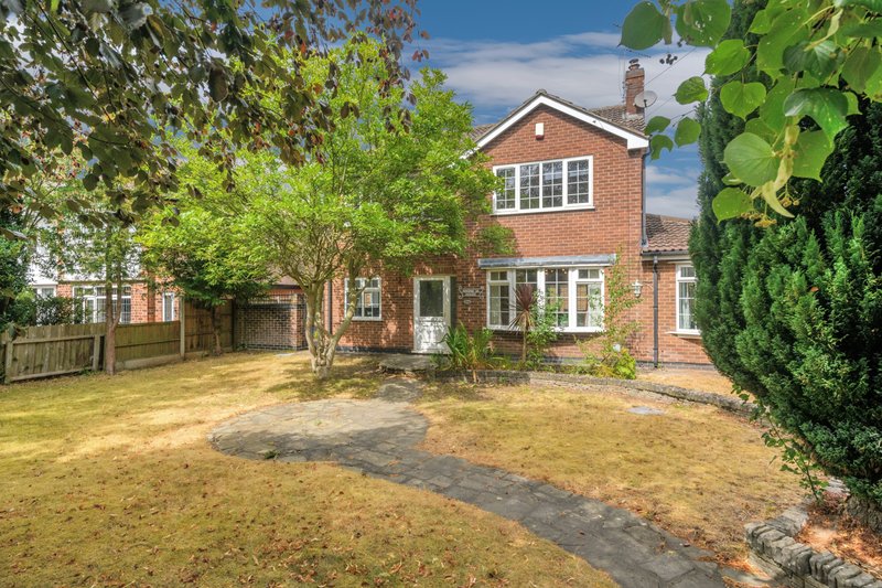 Brick detached house with garden, patio, and mature trees surrounding property