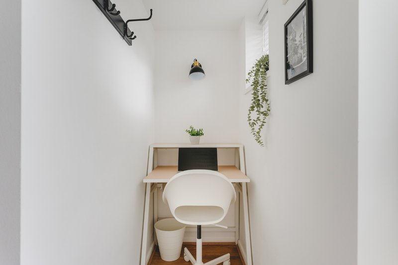 Small modern bathroom with white toilet, wooden vanity, pendant light and wall plants