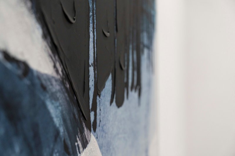 Close-up detail of painted wall corner with black and blue paint texture