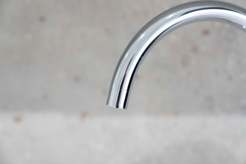 Chrome kitchen or bathroom tap over light speckled countertop