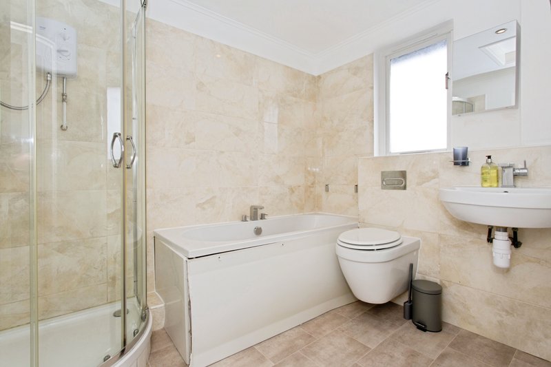 Bathroom with shower enclosure, bathtub, toilet, and wall-mounted sink with mirror