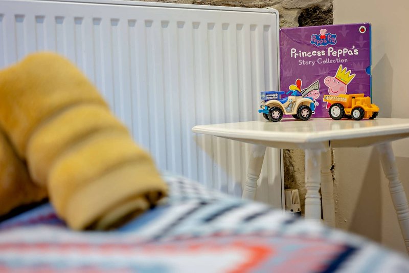 Bright nursery with white radiator, small white table with children's books and toys