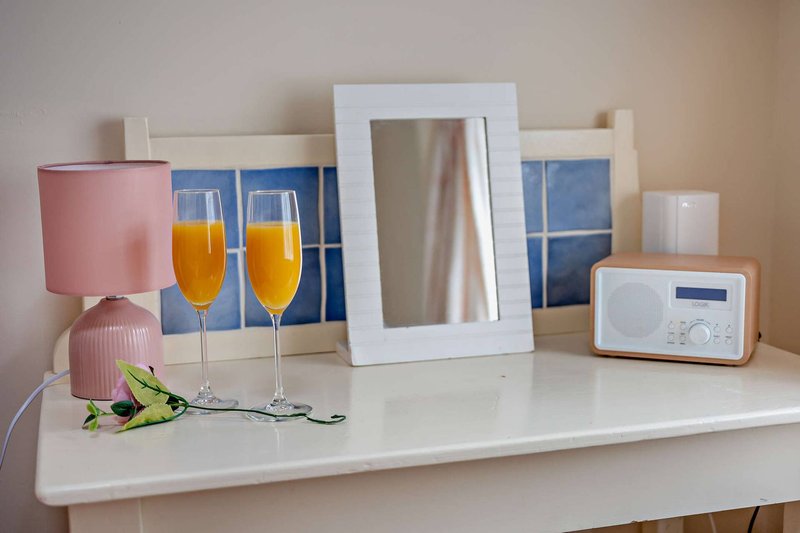 Bedroom shelf with mirror, glasses, flowers, microwave and decorative items
