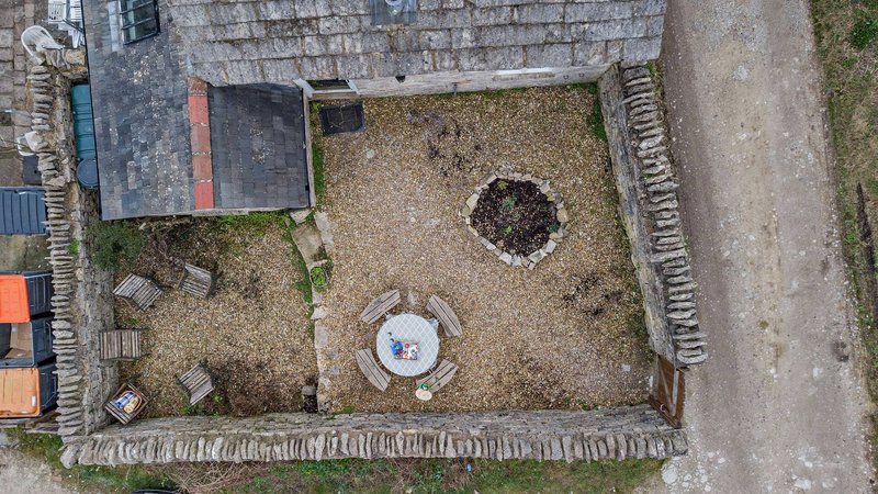 Aerial view of backyard with brick walls, patio area, and garden shed