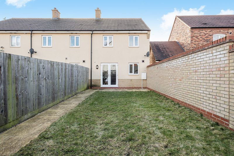 Rear garden view of terraced house with patio, fencing and brick boundary walls