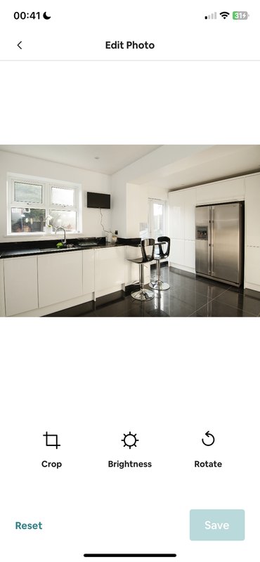 Modern white kitchen with black countertop, stainless steel appliances and island