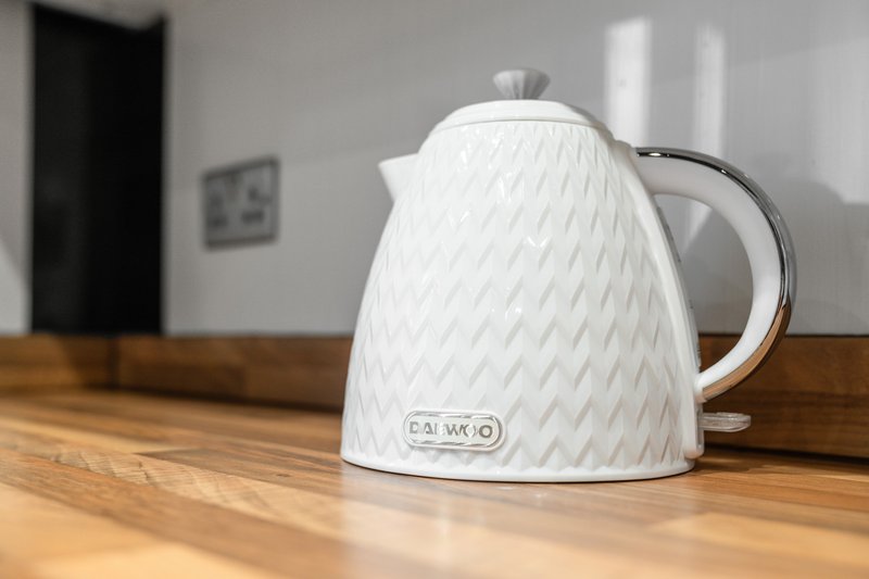 White electric kettle with quilted texture on wooden kitchen counter