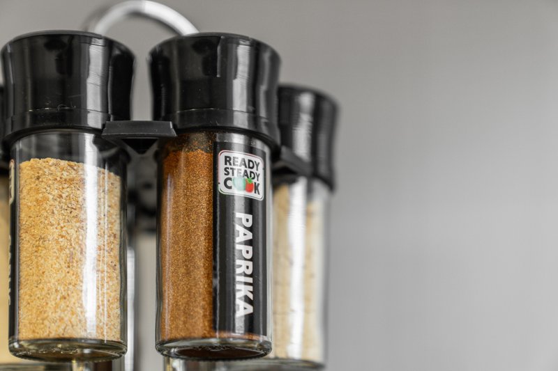 Spice rack with labeled glass jars containing dried seasonings and herbs
