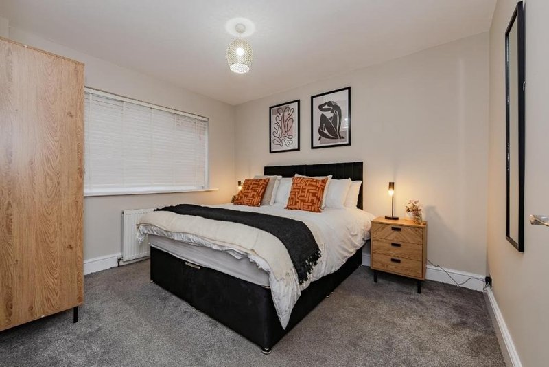 Modern bedroom with double bed, wooden wardrobe, bedside lamps and wall art