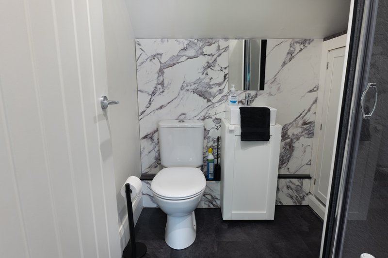 Fully stocked bathroom, with toilet, sink and shower.