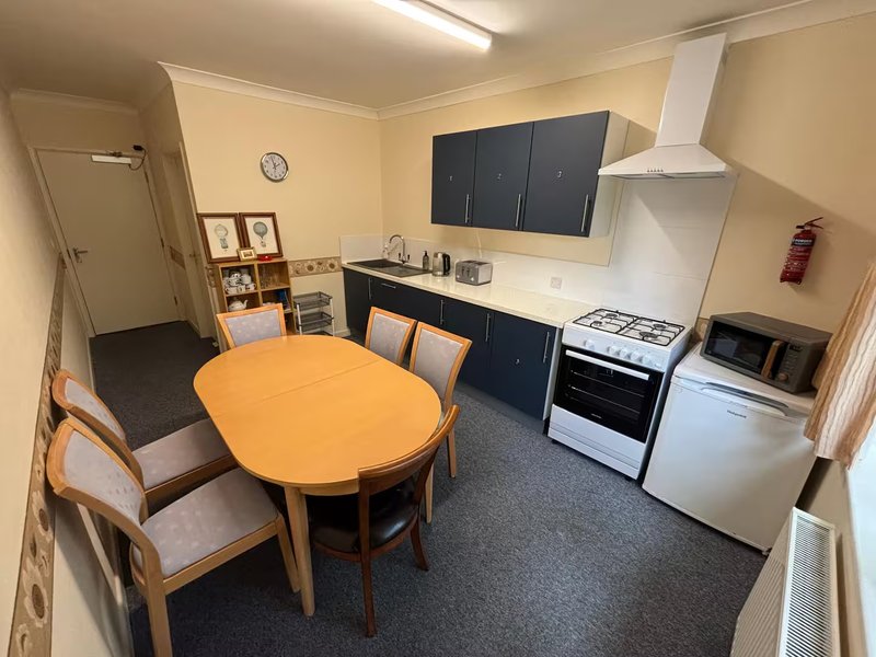 Kitchen-diner with round wooden table, fitted units, gas cooker and appliances