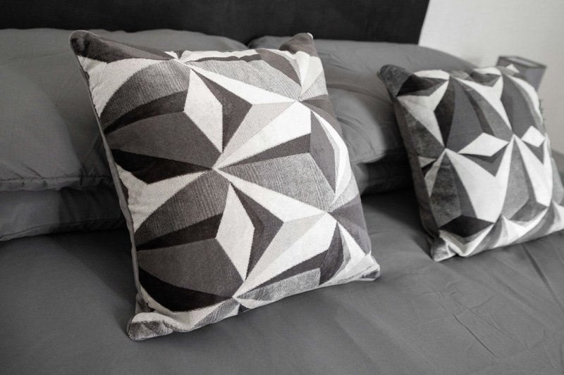 Gray sofa with patterned geometric cushions in monochrome tones