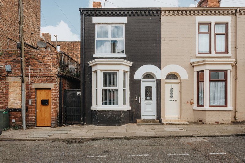 Row of brick terraced houses with varied facades and front doors on street