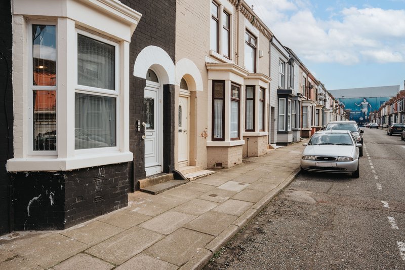 Terraced street of Victorian and Edwardian townhouses with bay windows and parked car