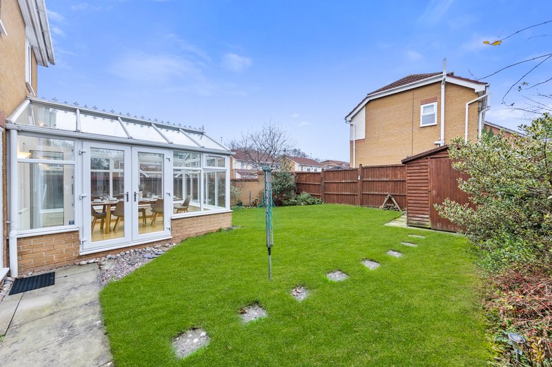 Residential garden with lawn, stepping stones, conservatory extension and brick house