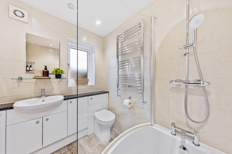 Modern bathroom with white vanity, vessel sink, toilet, shower enclosure and heated towel rail