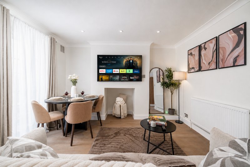 Modern living room with dining table, smart TV, fireplace, and contemporary furnishings