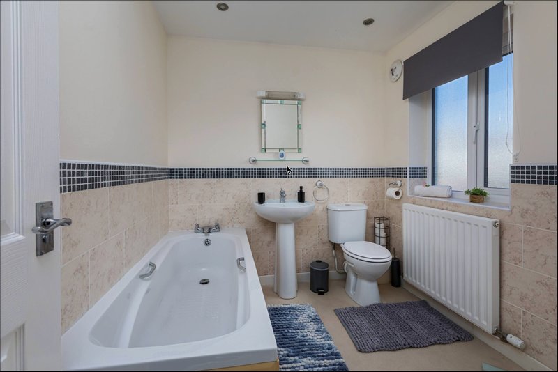 Bathroom with bathtub, pedestal sink, toilet, window and radiator