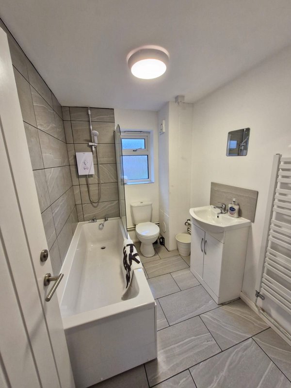 Modern bathroom with bathtub, shower enclosure, toilet, sink and heated towel rail