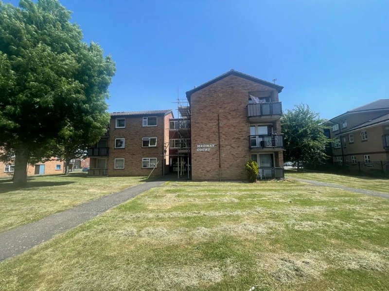 Brick apartment building with communal courtyard, grass area and surrounding residential properties