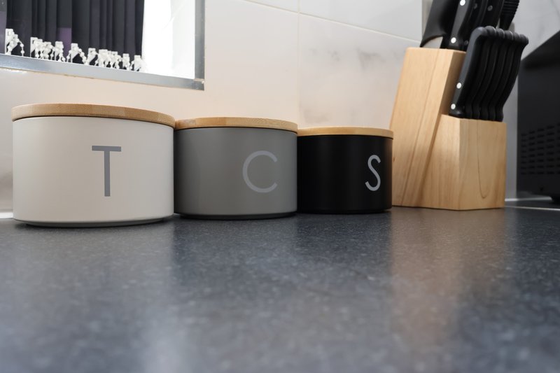 Kitchen counter with labeled storage containers and wooden utensil holder