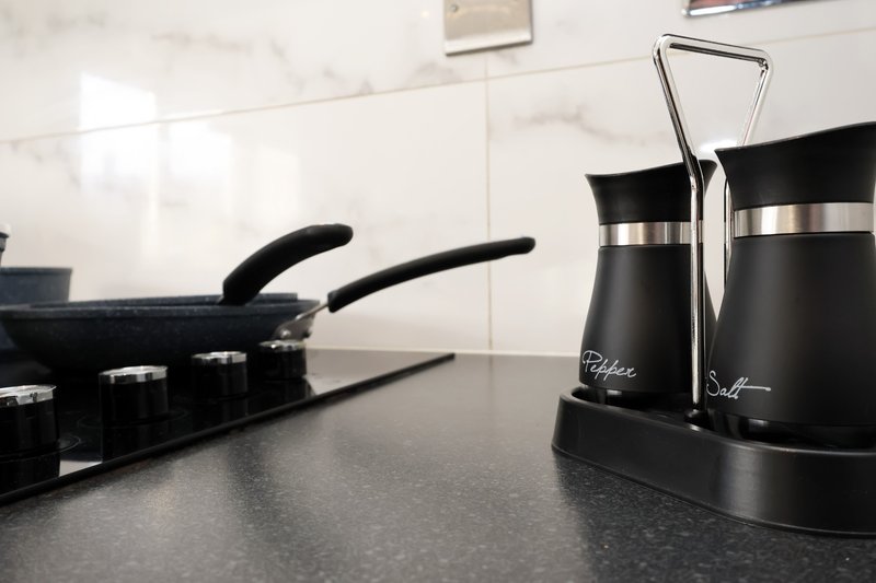 Modern kitchen countertop with black kettle, coffee maker and cookware