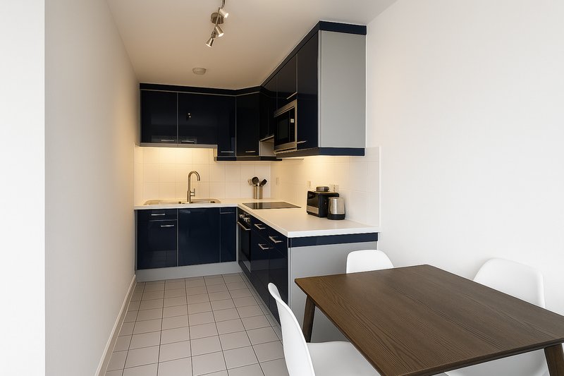 Modern kitchen with black cabinets, white countertop, and dining table in foreground
