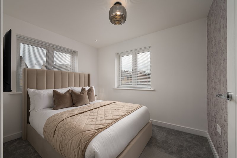 Modern bedroom with upholstered headboard, double bed, pendant light and two windows