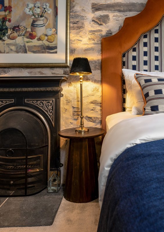 Bedroom with fireplace, bedside lamp, framed wall art, and decorative pillows