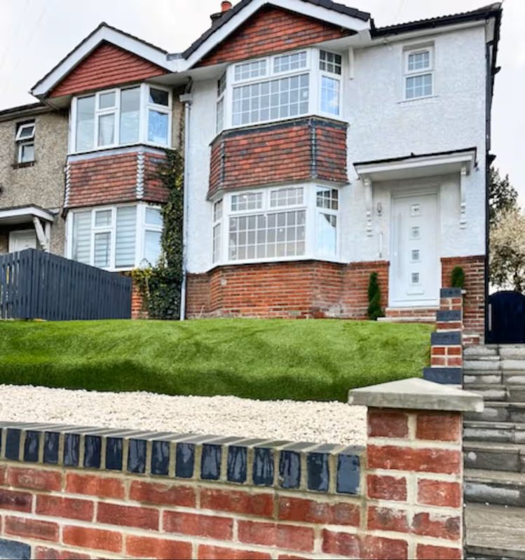 Modern two-storey semi-detached house with brick and render exterior, bay windows, driveway and front garden