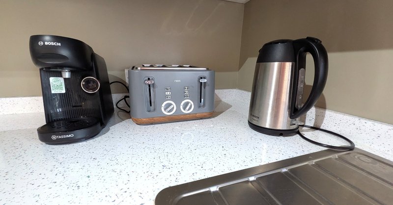 Kitchen countertop with coffee maker, toaster, and electric kettle appliances